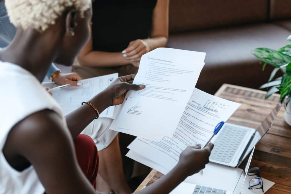 A person reviewing two different documents.