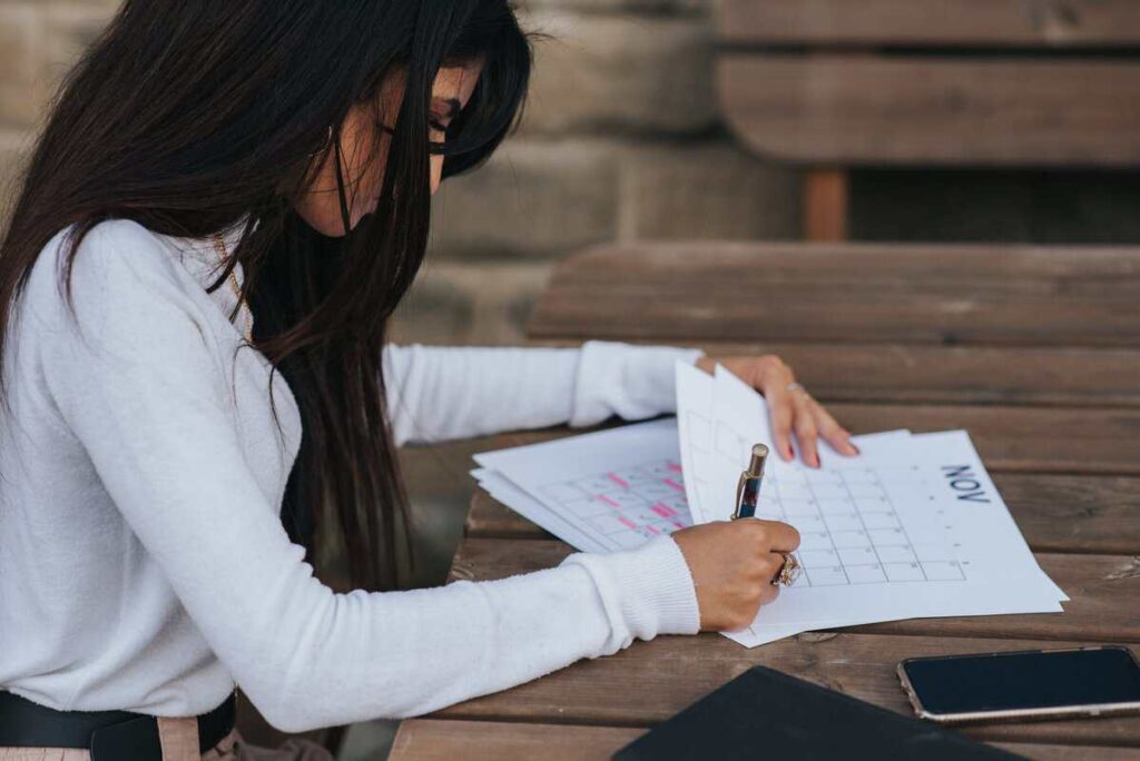 A person reviewing a calendar and paperwork.