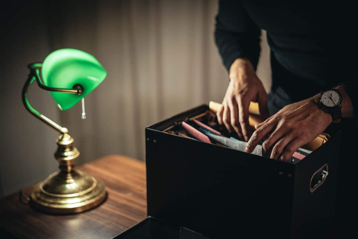 A person looking through a file box.