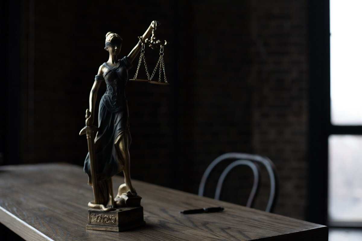 A justice statue on an empty desk.