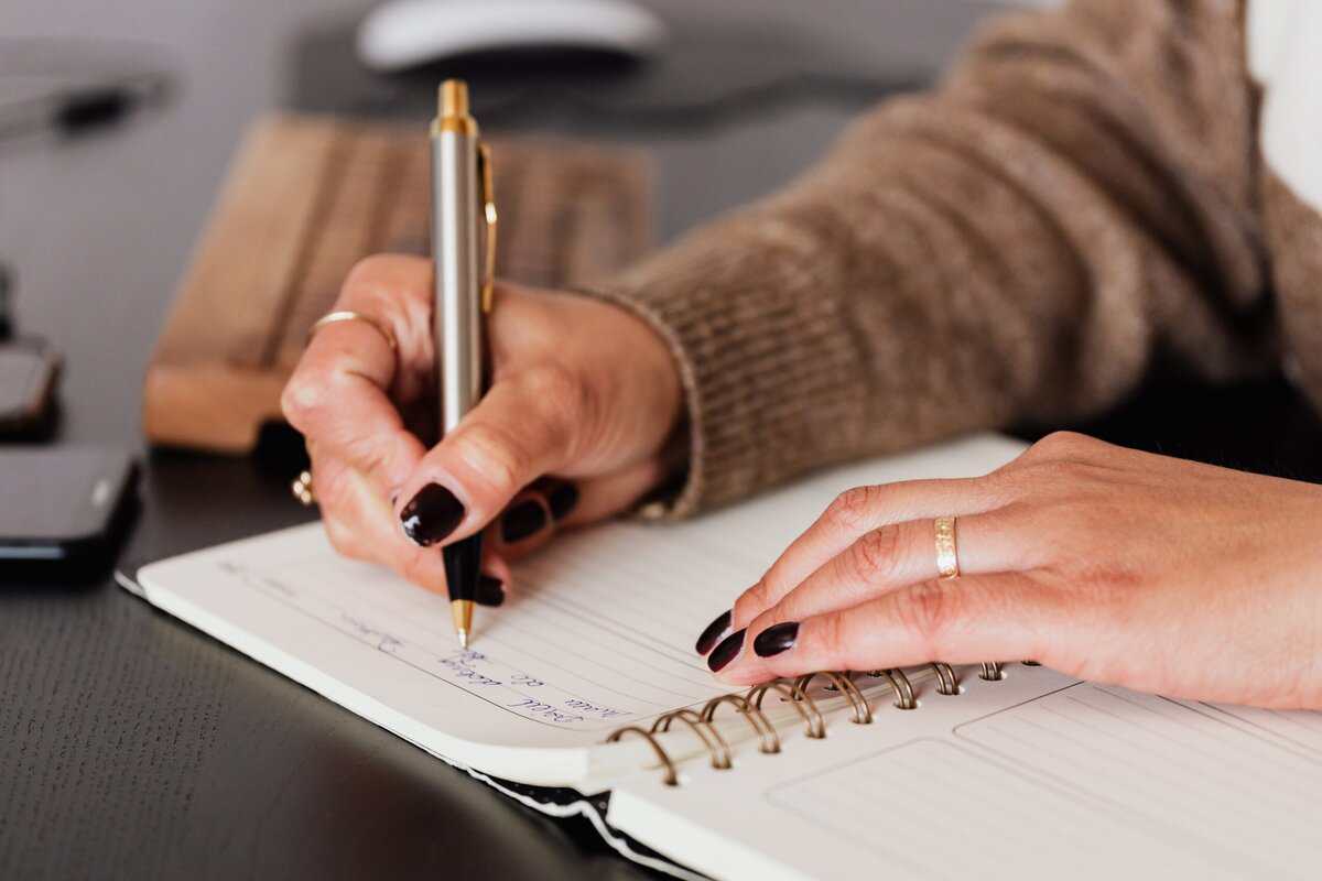 A person writing in a planner.