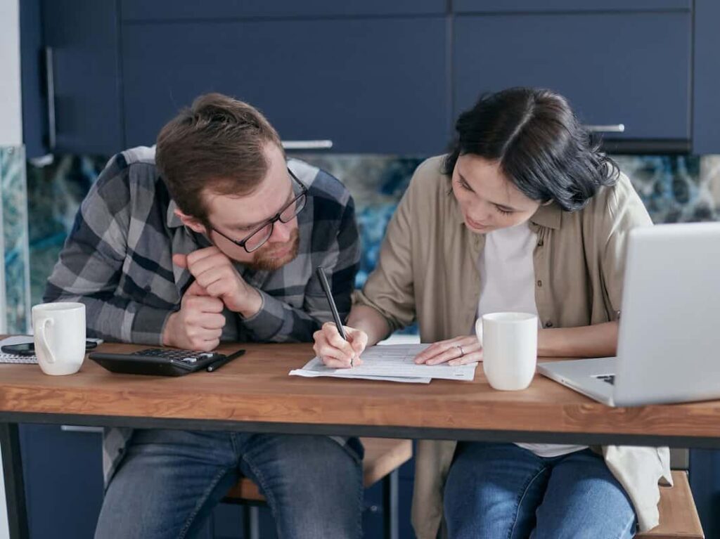 Two people looking at the same document.