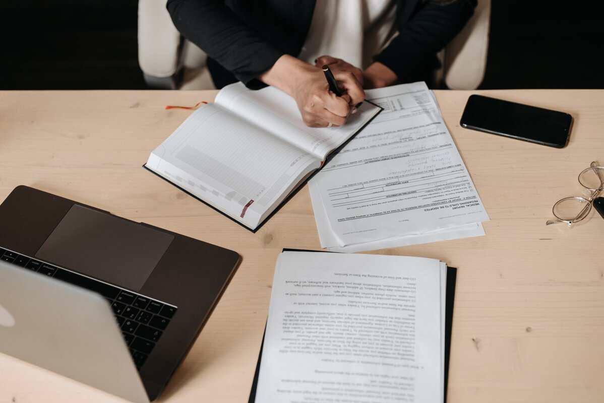 A person at a desk writing in a notebook.