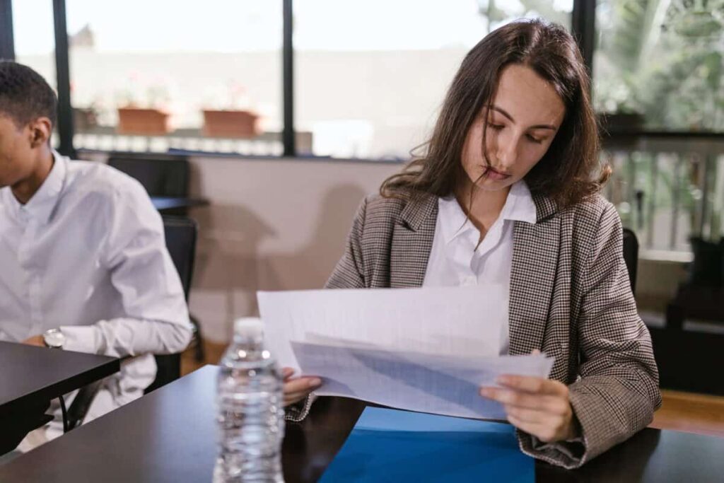 A person holding documents at a desk.