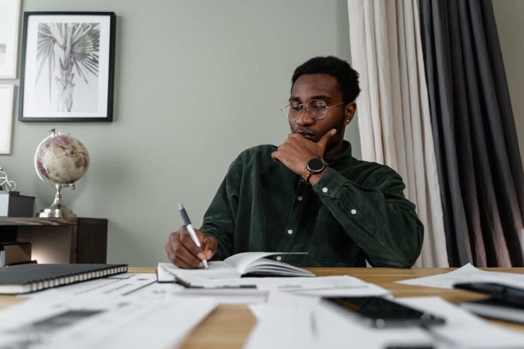 A person writing on documents at a desk.