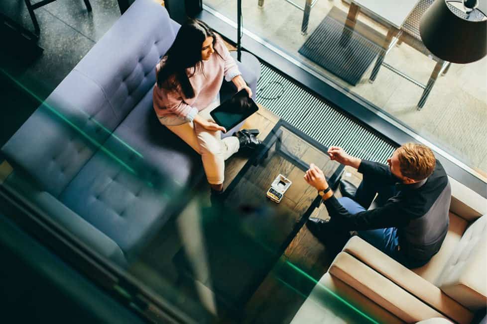 two people in serious discussion in casual seating area