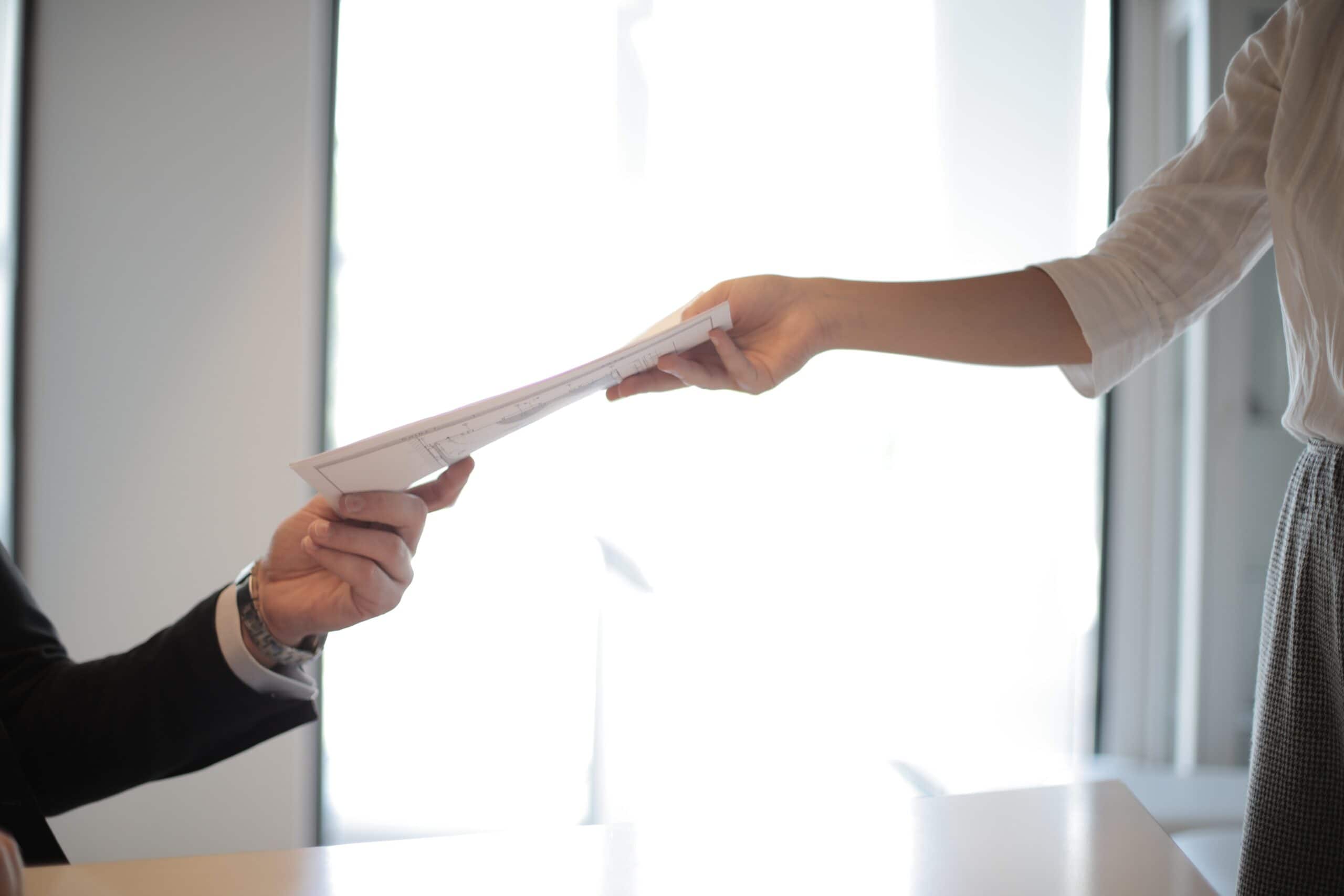 A piece of paper being handed off